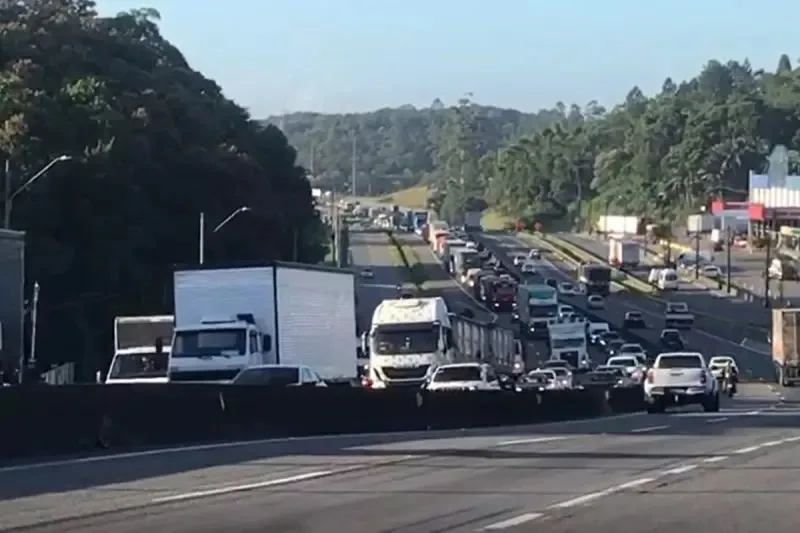 Trânsito carregado e repleto de carros na BR-101 com caminhões em destaque