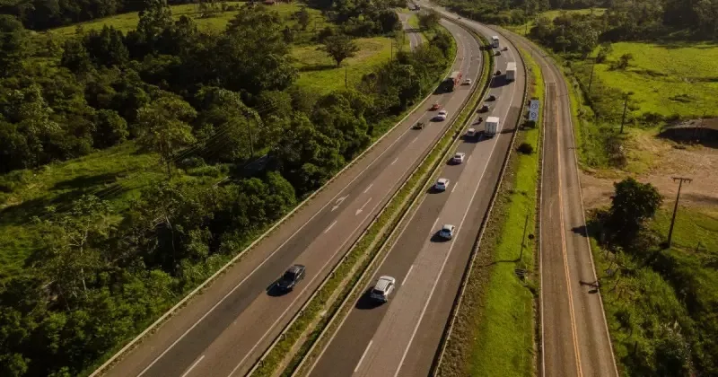 Trecho da BR-101, visto de cima, com carros andando e mato ao redor