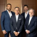 Executivos da Revo e Carbon reunidos com fundo escuro