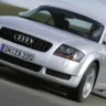 Audi TT Coupé prata de frente andando na estrada