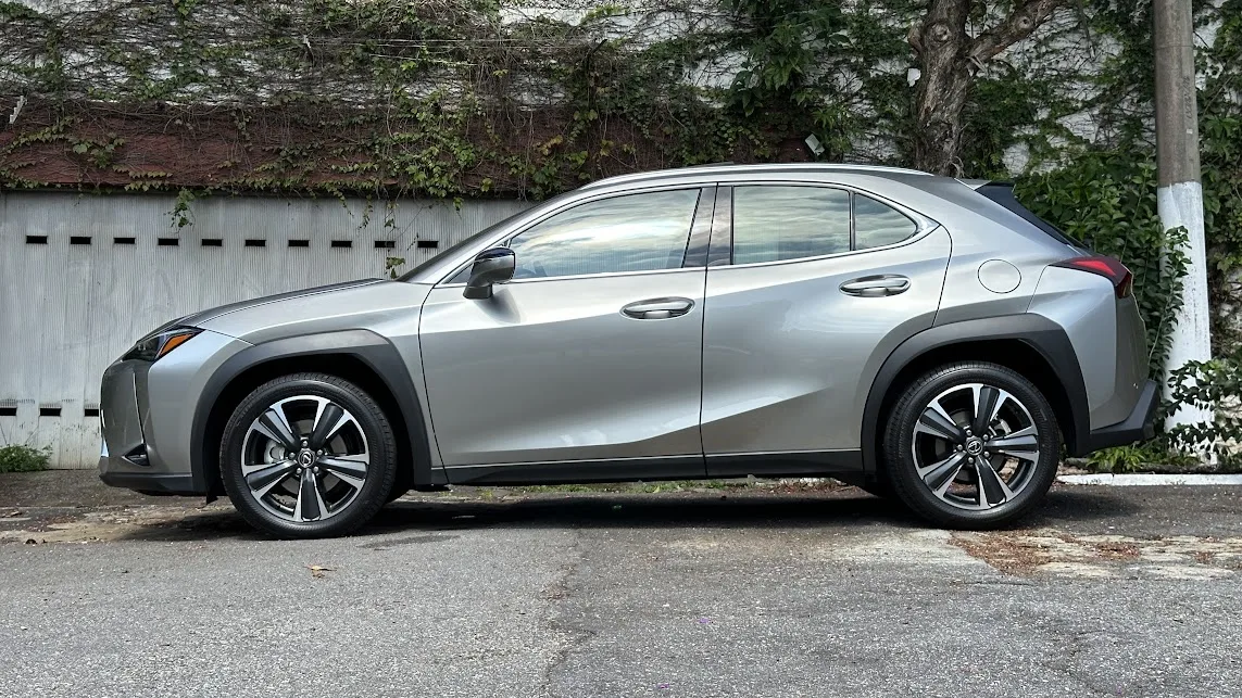 Lexus UX 300h cinza parado de lateral com casa ao fundo