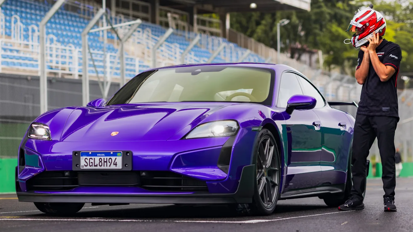 Porsche Taycan Turbo GT com Pacote Weissach roxo, visto de frente, com faróis acesos e piloto ao lado