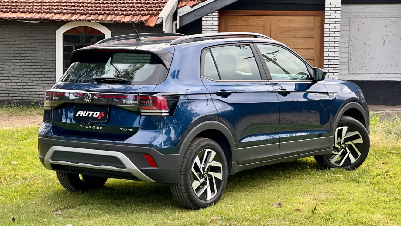 Volkswagen T-Cross Comfortline azul de traseira em um gramado com uma casa ao fundo