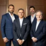 Executivos da Revo e Carbon reunidos com fundo escuro
