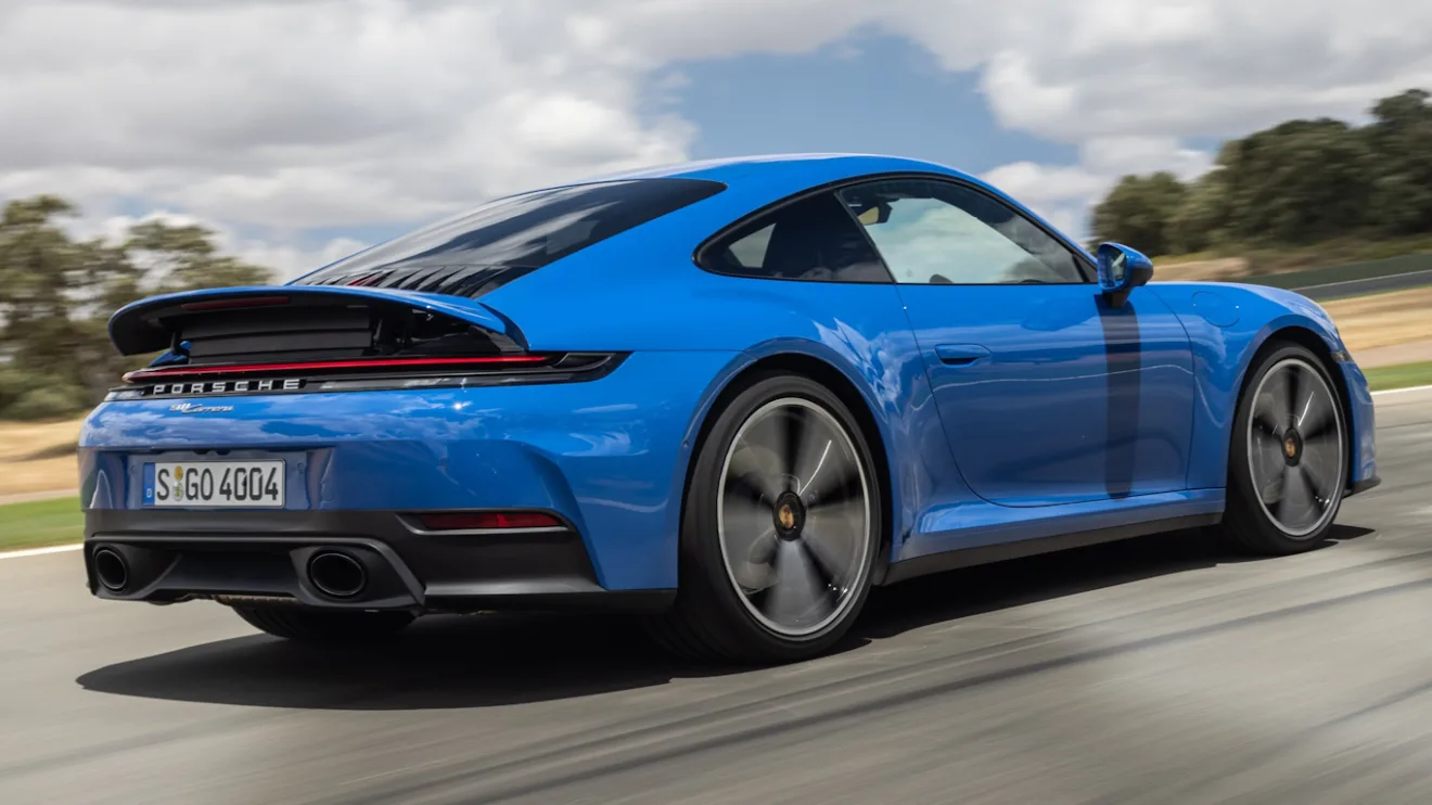 Novo Porsche 911 Carrera Coupé azul, visto de trás e andando em pista