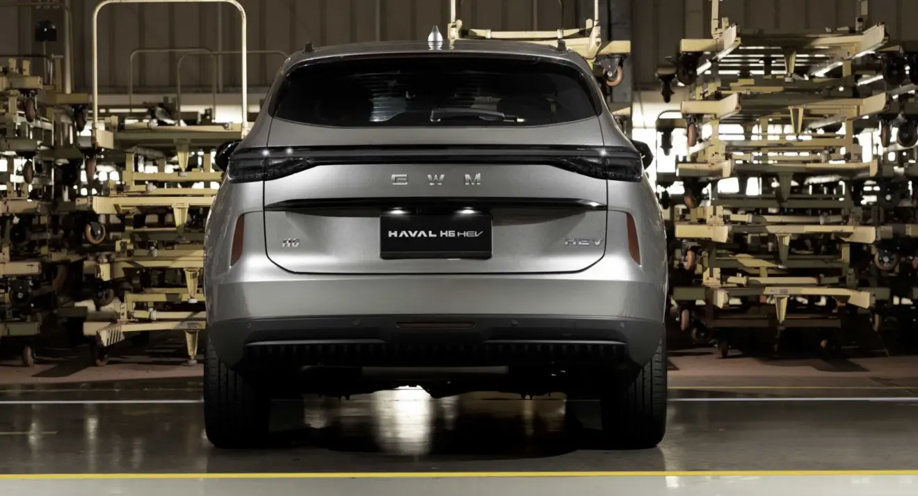 GWM Haval H6 cinza parado de traseira na fábrica