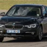 BMW 320i preta andando na pista é um carro que pode ser usado em Track Day