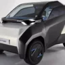 Toyota FT-Me Concept prata com partes pretas, visto de frente e com faróis acesos