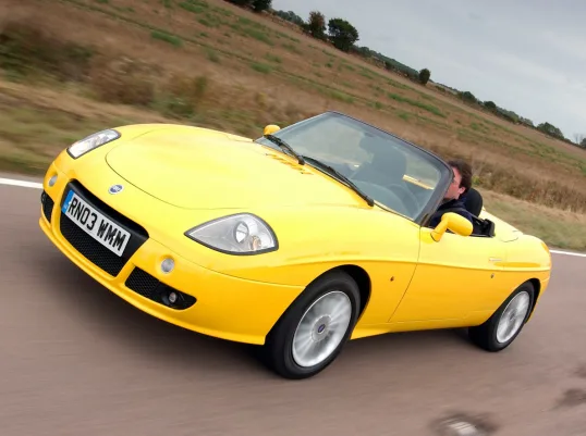 Fiat Barchetta amarelo andando na estrada é um dos exemplos de roadster que deixou saudades