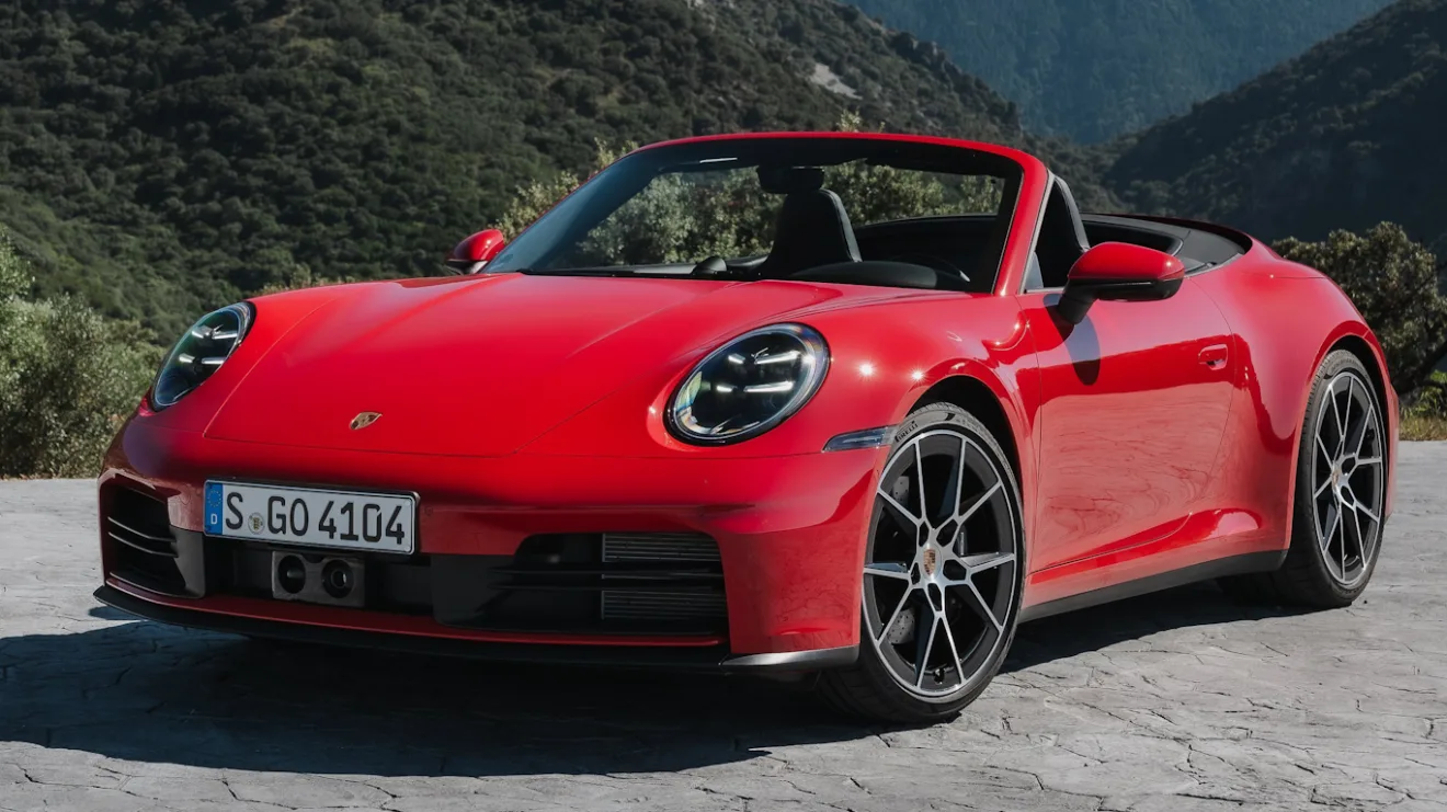 Novo Porsche 911 Carrera Cabriolet vermelho, com faróis acesos, visto de frente