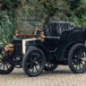 Panhard et Levassor Type A preto parado de frente com árvores ao fundo