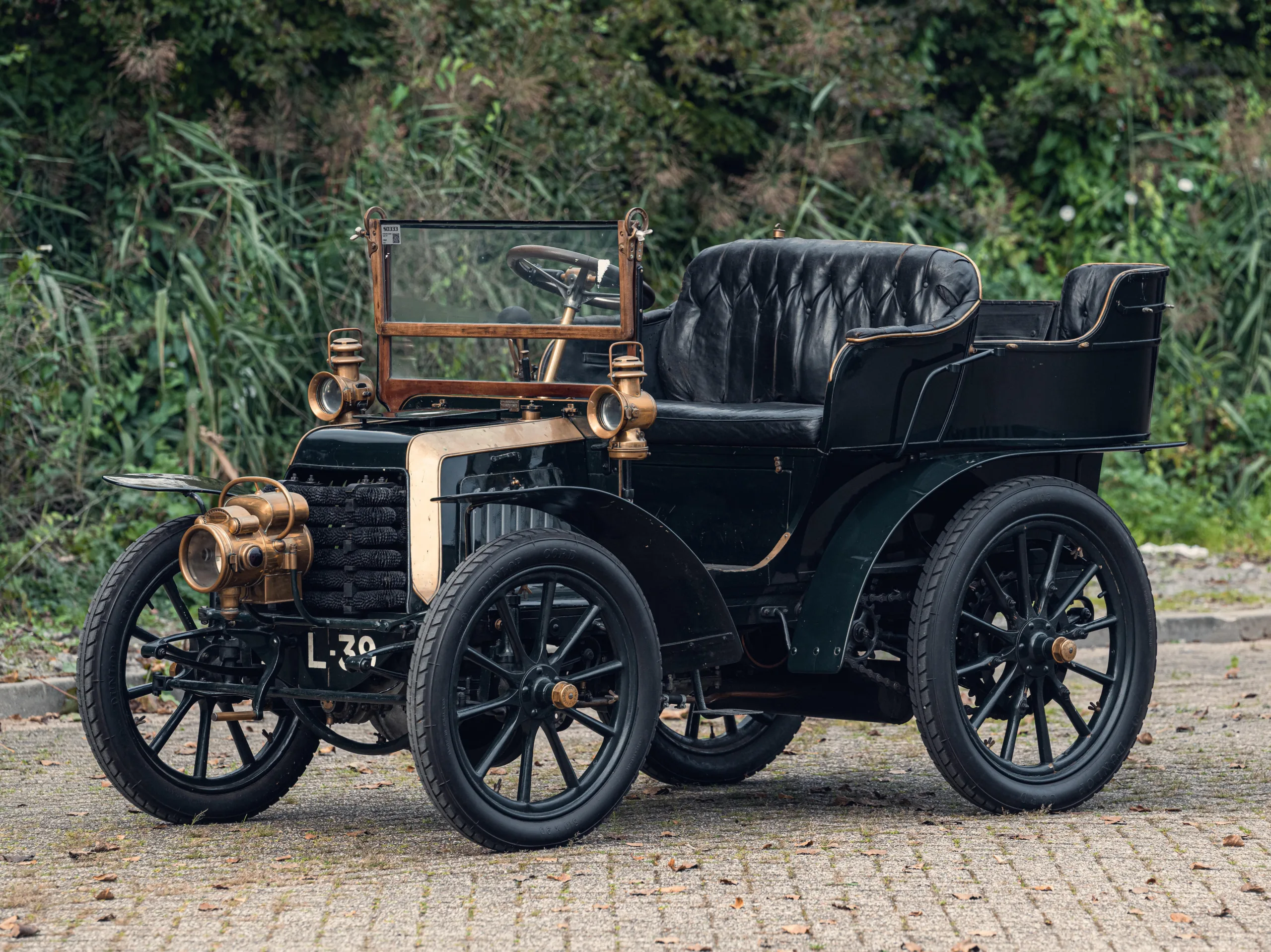 Panhard et Levassor Type A preto parado de frente com árvores ao fundo