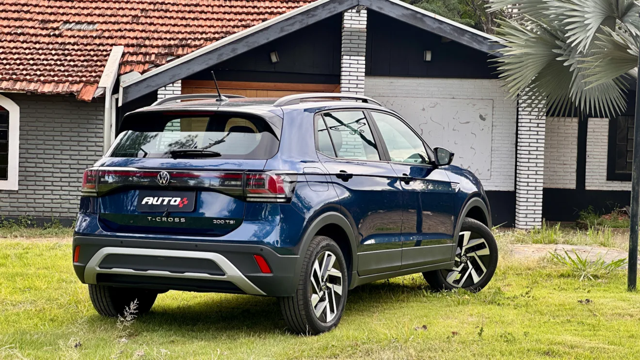 Volkswagen T-Cross Comfortline azul de traseira em um gramado com uma casa ao fundo