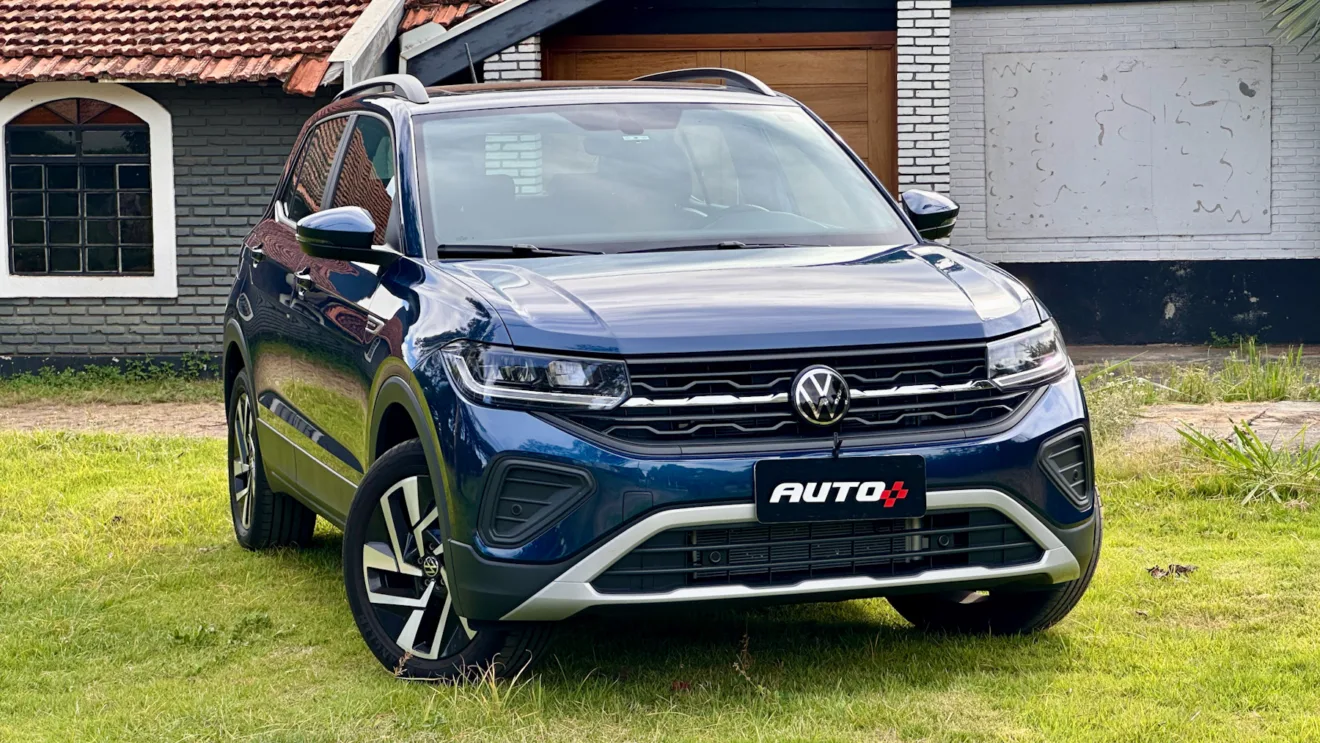 Volkswagen T-Cross Comfortline azul de frente em um gramado com uma casa ao fundo