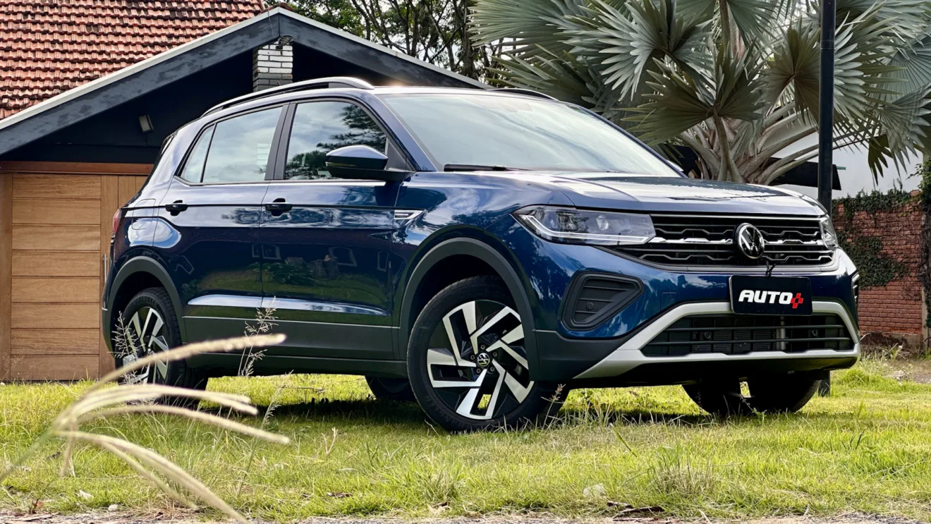 Volkswagen T-Cross Comfortline azul de frente em um gramado com uma casa ao fundo
