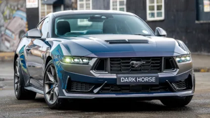 Ford Mustang Dark Horse manual azul de frente com faróis acesos