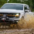 Ford F-150 Tremor branca de frente passando por um lamaçal