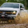 Ford F-150 Tremor branca de frente passando por um lamaçal