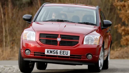 Dodge Caliber vermelho de frente fazendo uma curva forte