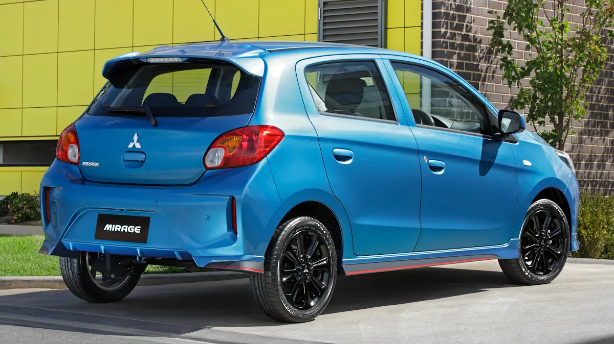 Mitsubishi Mirage azul de traseira em uma parede amarela Volkswagen Gol japonês carro popular