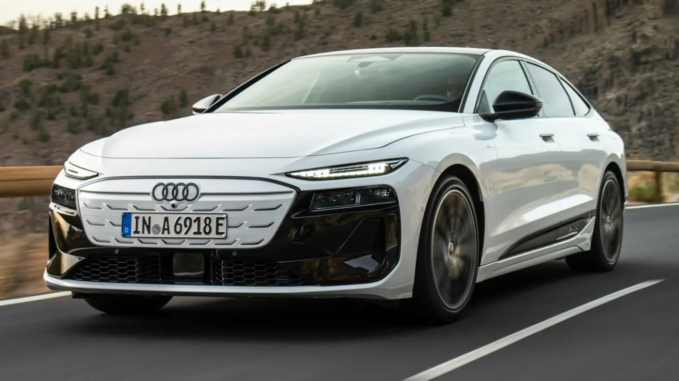 Audi A6 e-Tron Sportback branco, visto de lado, com faróis acesos e em pista