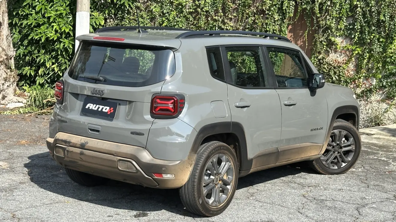 Jeep Renegade Longitude Night Eagle cinza parado de traseira com muro e plantas ao fundo