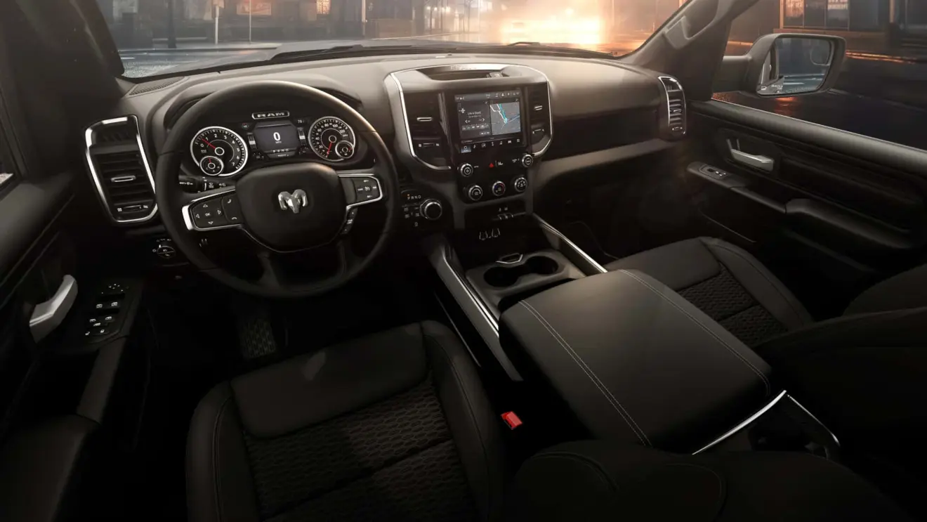 Interior da Ram 1500 Express 2026 com painel de instrumentos e central multimídia ligados caminhonete grande