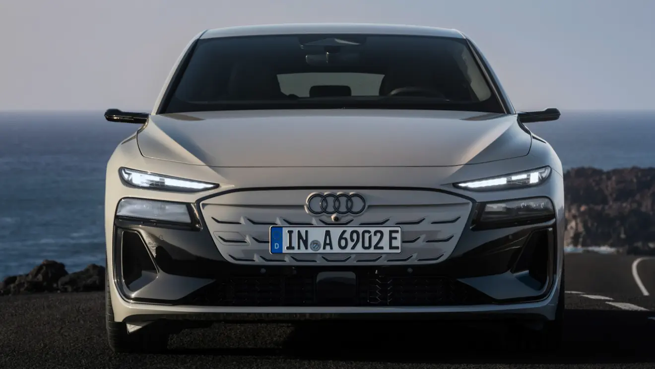 Audi A6 e-Tron Sportback acinzentado, visto de frente e com faróis acesos