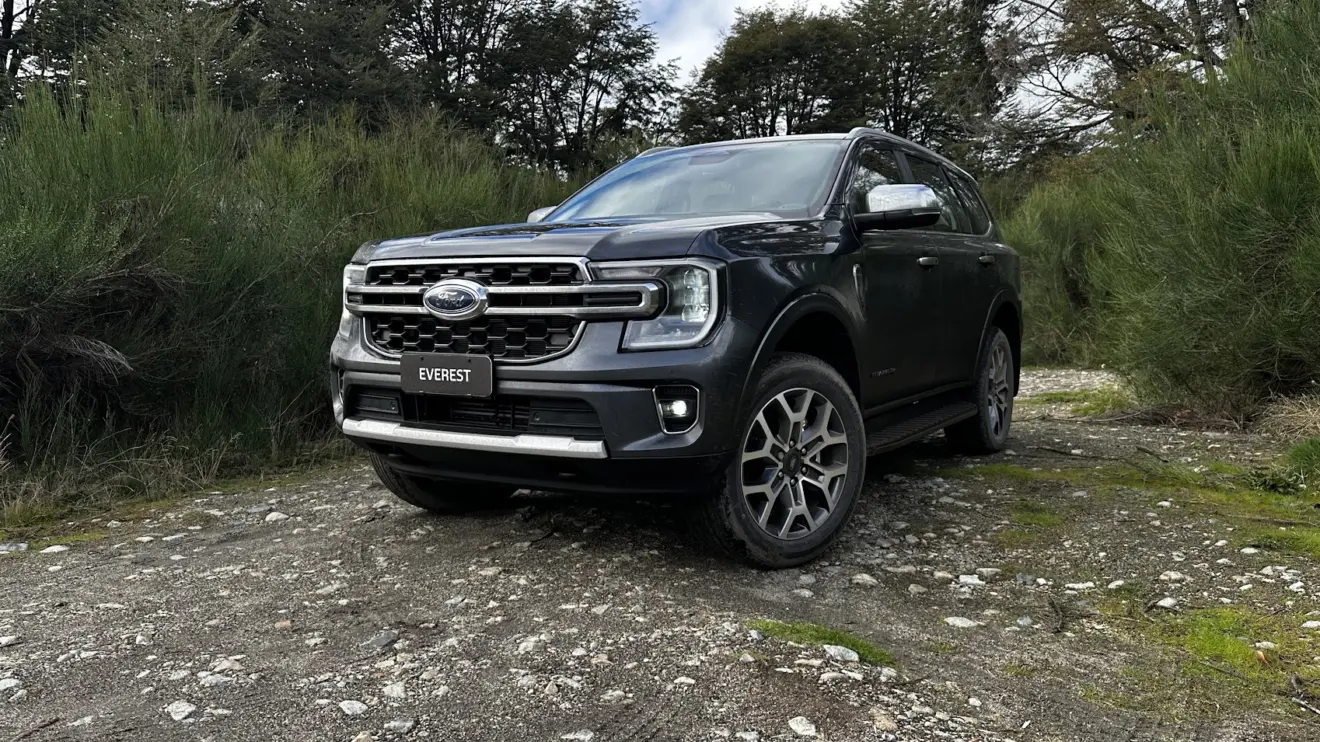 Ford Everest Titanium cinza parado de frente com árvores ao fundo