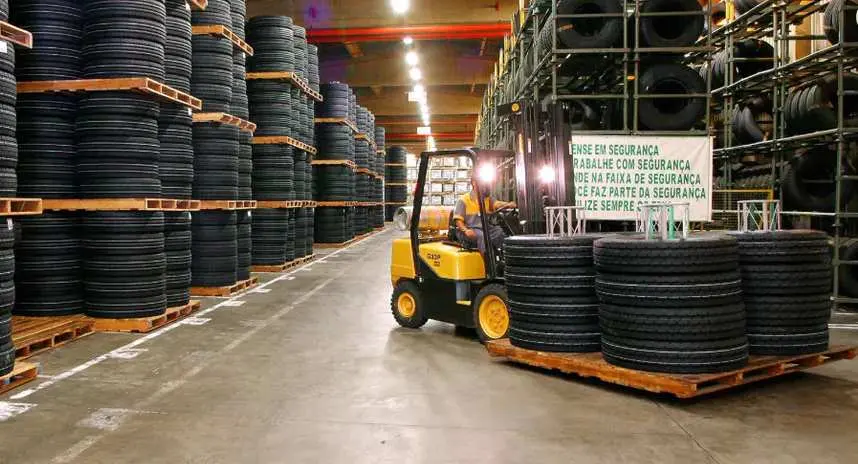 Empilhadeira amarela transportando pneus na fábrica da Michelin