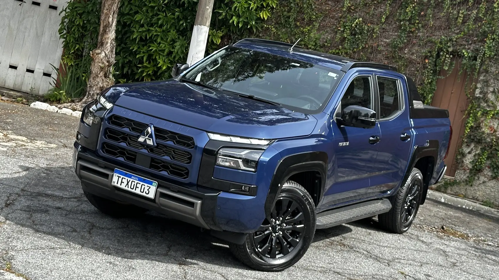 Caminhonete média Mitsubishi Triton Katana azul parada de frente e vista do alto