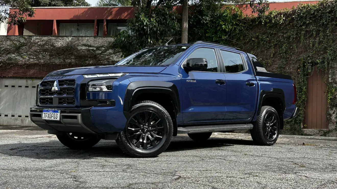 Mitsubishi Triton Katana azul parada de frente e lateral com muro ao fundo