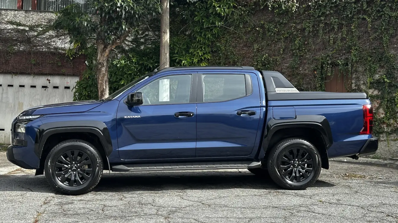 Nova Mitsubishi Triton Katana azul parada de lateral com muro ao fundo