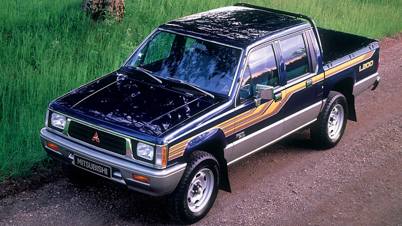 Mitsubishi L200 preta com detalhes coloridos e vista de cima