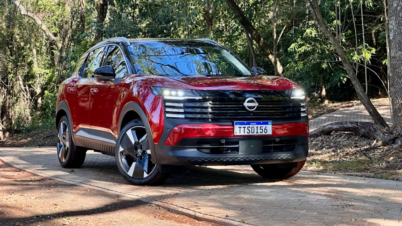 Nissan Kicks Platinum 2026 vermelho de frente em uma floresta