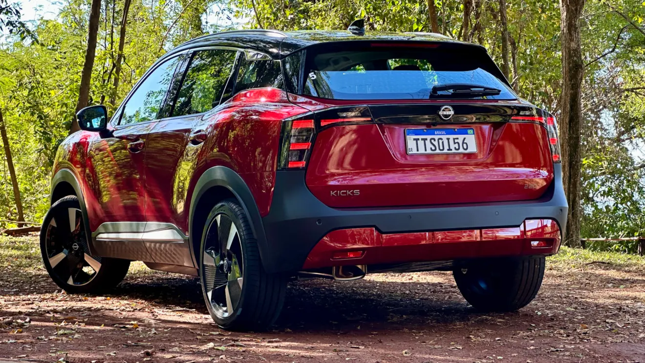 Nissan Kicks Platinum 2026 vermelho de traseira em uma floresta