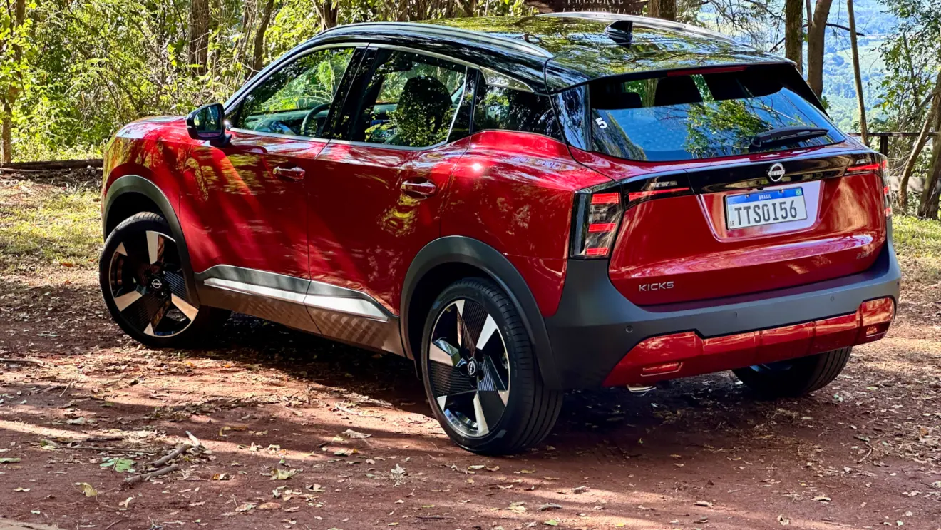 Nissan Kicks Platinum 2026 vermelho de traseira em uma floresta