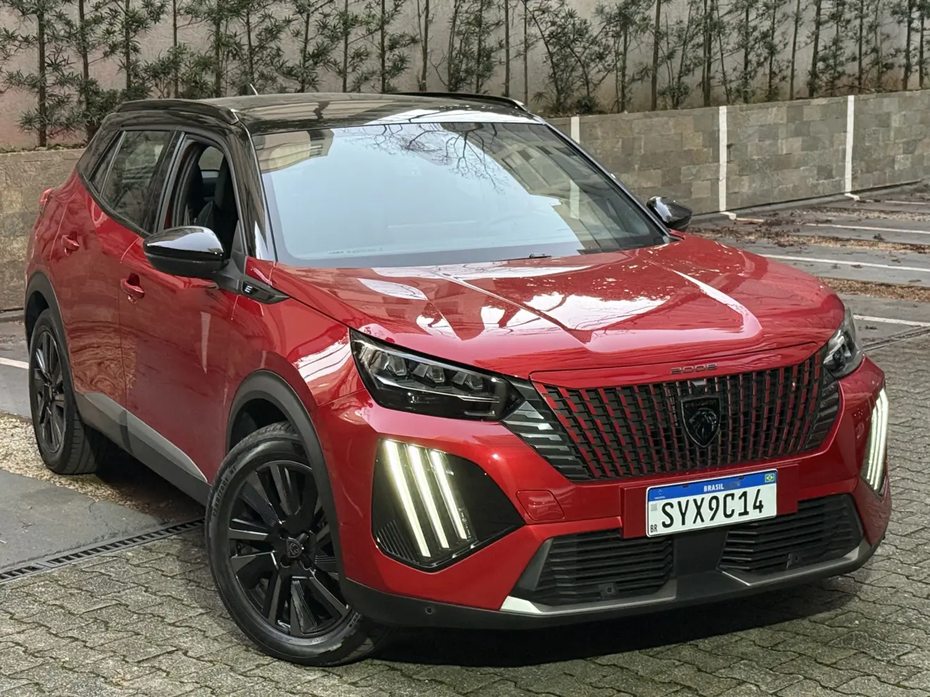 Peugeot e-2008 GT vermelho com partes pretas, DRL's acesos e visto de frente