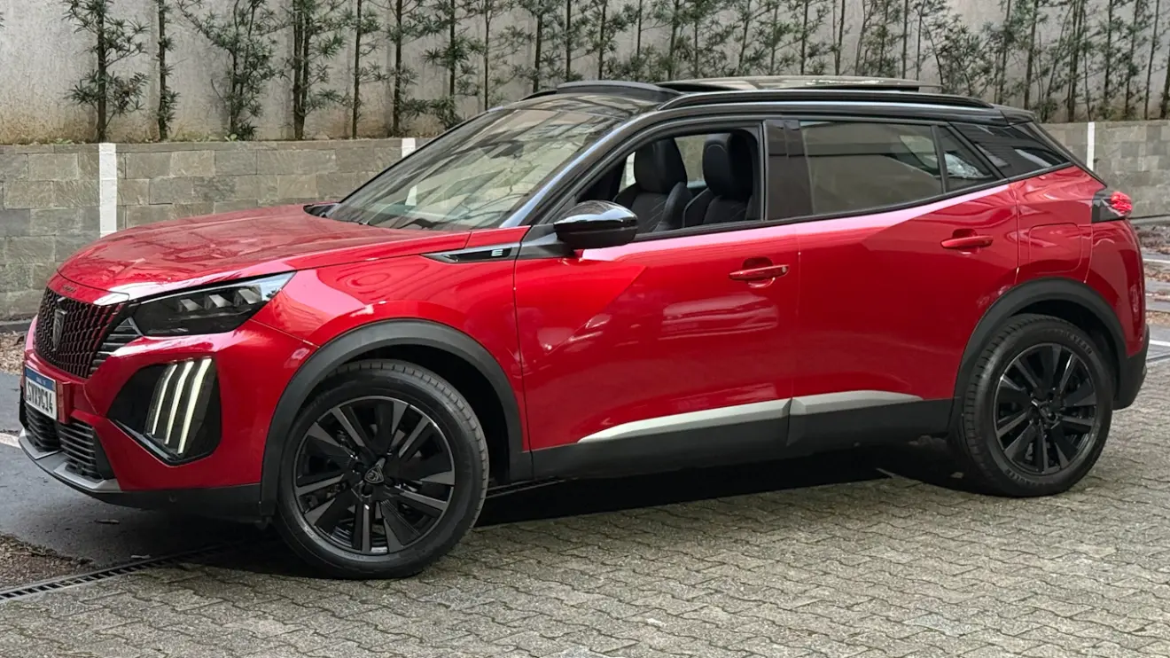 Peugeot e-2008 GT vermelho com partes pretas, visto de lado