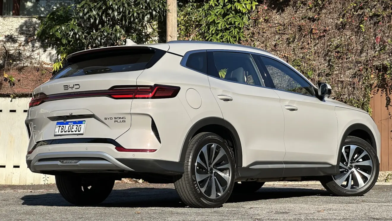 BYD Song Plus 2026 dourado parado de traseira com muro e plantas ao fundo