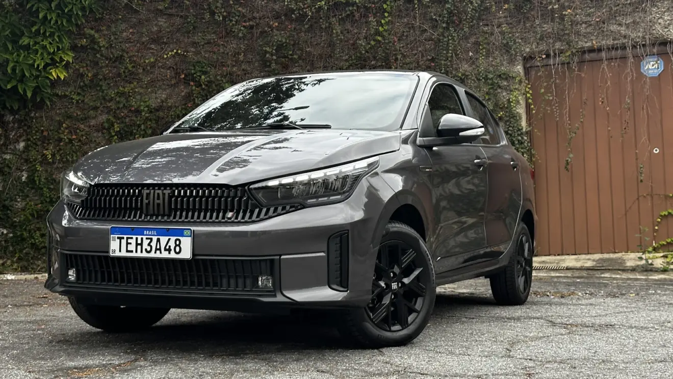 Fiat Cronos Drive S-Design cinza parado de frente com muro e portão de madeira ao fundo