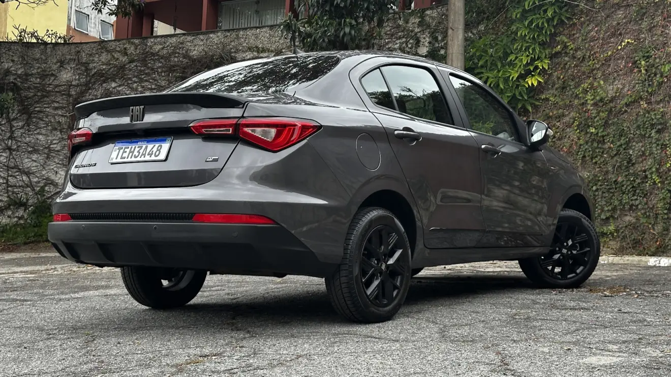 Fiat Cronos Drive S-Design cinza parado de traseira com muro e portão de madeira ao fundo