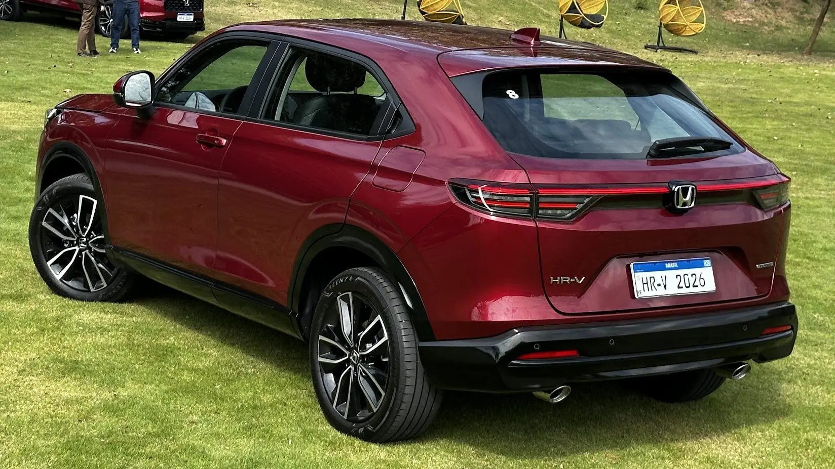 Honda HR-V Touring 2026 vermelho parado de traseira na grama