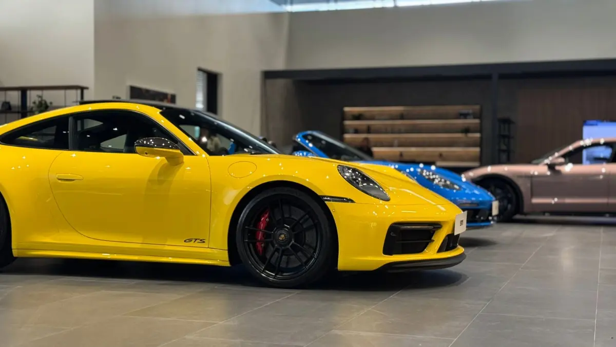 Showroom da Porsche em São Paulo, com 911 GTS amarelo e 911 azul