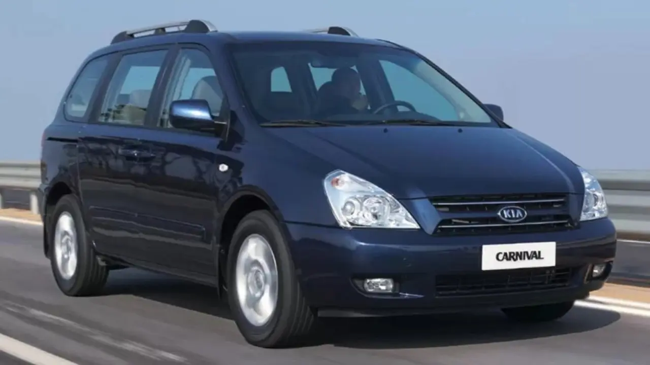 Kia Carnival azul em movimento de frente e lado