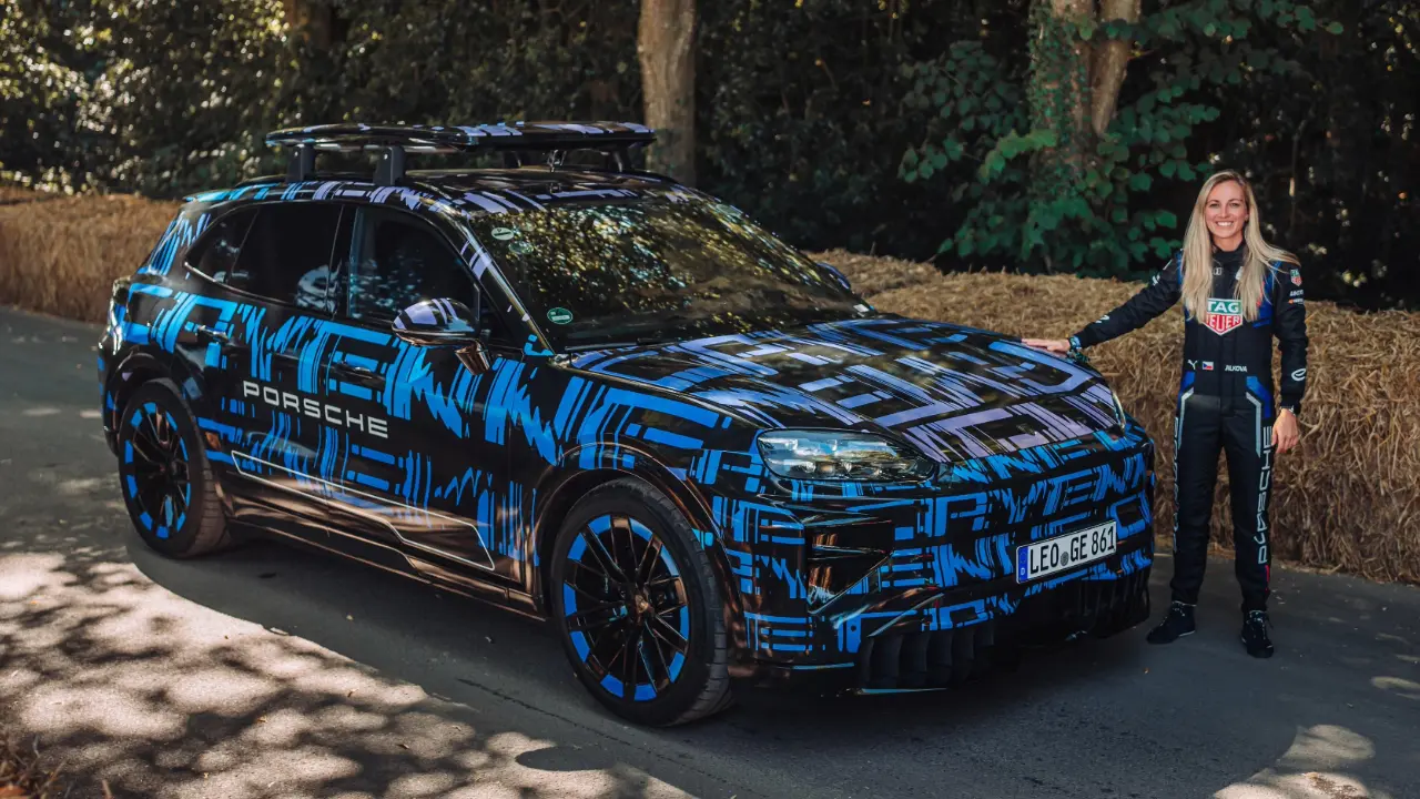 Porsche Cayenne de quarta geração elétrico de lado camuflado com a piloto Gabriela Jílková, da equipe de Fórmula E da Porsche