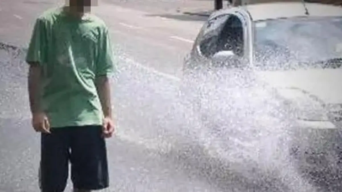 Pedestre sendo molhado enq1uanto carro passa por poça de água