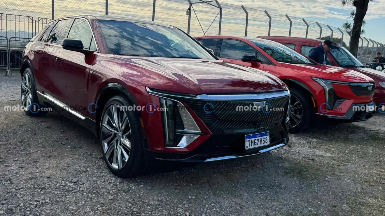 SUVs Optiq e Lyric da Cadillac avermelhados e vistos de frente