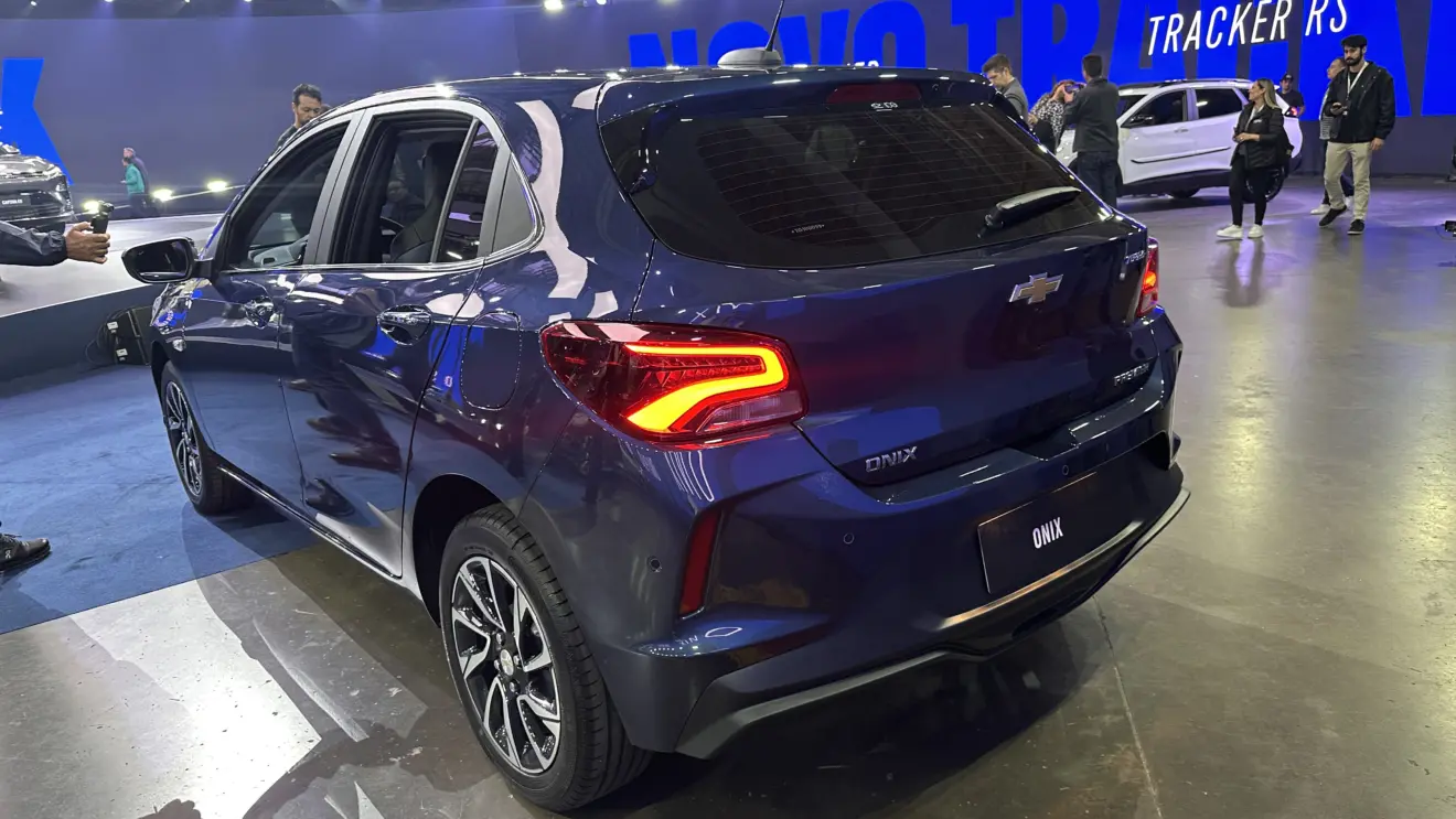 Chevrolet Onix Premier 2026 azul visto de trás e com lanternas acesas