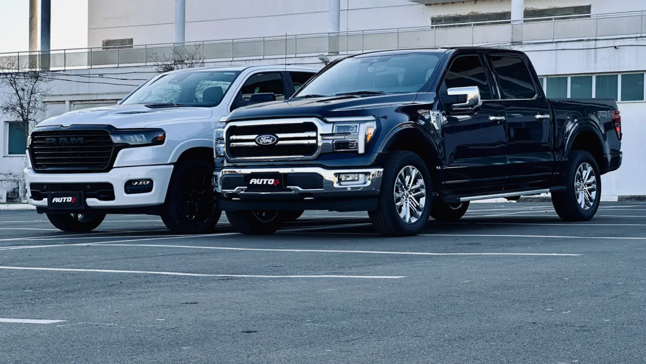 Ford F-150 Lariat azul ao lado de uma Ram 1500 Larait branca ambas de frente em um estacionamento